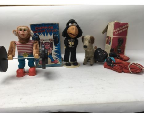 A collection of toy items to include a 1960s Japanese weight lifting monkey in original box, a hand puppet of a boxer in orig