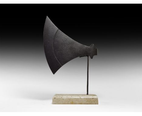 9th-11th century AD. An iron broad axehead of asymmetrical profile with reinforced curved cutting edge, triangular-section so