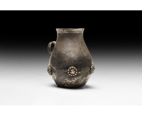 4th-5th century AD. A silver vase with discoid flat base, globular body, gently narrowing to the neck, flared rim; applied lo