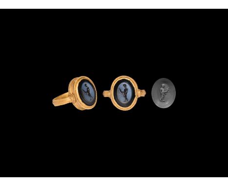 1st-3rd century AD. A D-section gold hoop with flat borders and flared shoulders supporting a discoid bezel with beaded wire 