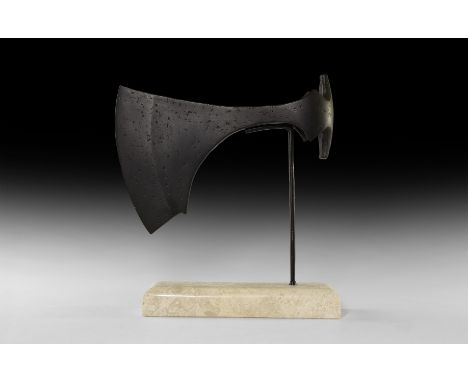 9th-11th century AD. An iron axehead with slender blade and chin to the lower edge; round socket with lateral triangular flan