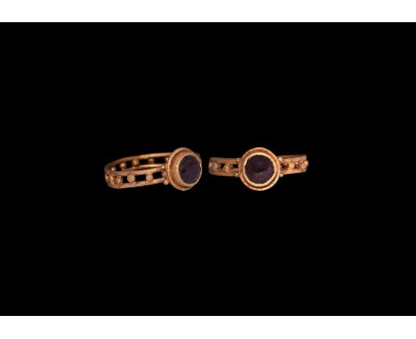 Later 6th century AD. A gold ring comprising an openwork hoop of two bands with eighteen granules between, discoid bezel with