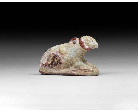 Late Period, 664-332 BC. A composition amulet in the form of a ram reclining on a base, suspension loop to the back of the ne