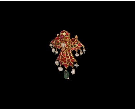 19th century AD. A gold pendant of a bird with wings extended and suspension loops to the pinions; inset cabochon rubies to t