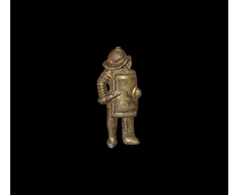 2nd century AD. A silver-gilt plate brooch depicting a murmillo gladiator standing with crested helmet, gladius held across t