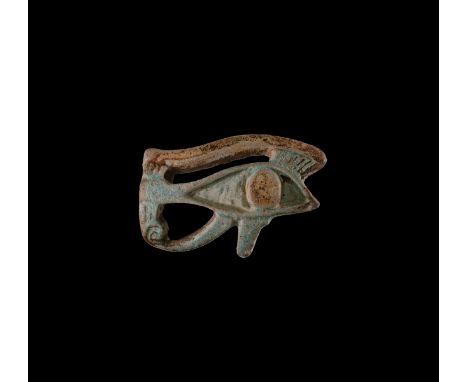 Late Period, 664-332 BC. A glazed composition amulet in the form of an openwork Eye of Horus with detail to the eyebrow and i