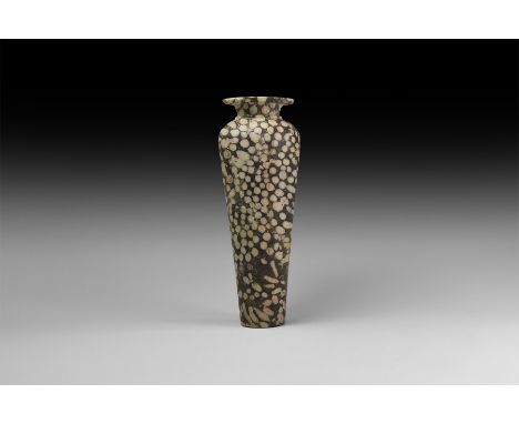 Early Dynastic Period, early 3rd millennium BC. A slender vase with tapering body, everted rim, carved from fossiliferous bla