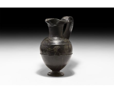 6th century BC. A large ceramic black-glazed bucchero oinochoe with wide mouth pinched to the front and sieve at the lip; tub