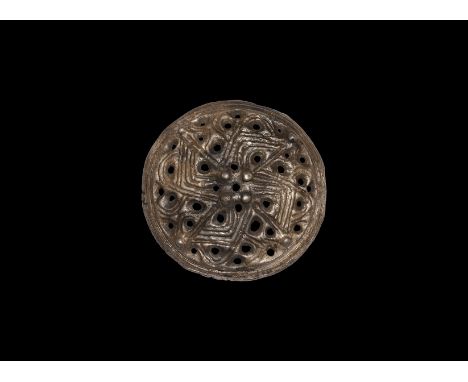 9th century AD. A substantial silver dome-shaped brooch formed as a convex plaque with openwork fylfot design, pellets to eac