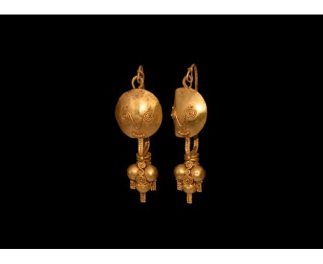 3rd century AD. A matched pair of gold earrings, each a double twisted loop and discoid shield with applied filigree and gran