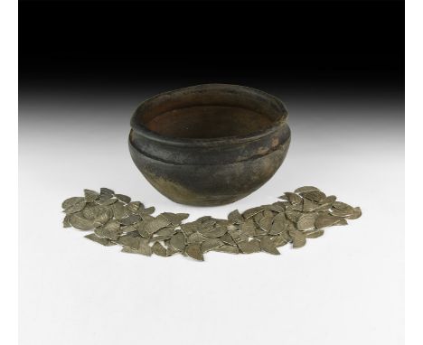 9th-11th century AD. A group comprising: 117 pieces of silver Islamic dirhems, snapped or cut, and a ceramic pot with flat di