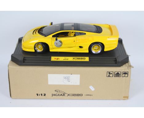 Maisto - A boxed 1:12 scale Maisto Racing Jaguar XJ220. The large model in yellow appears to be in Excellent dusty condition 