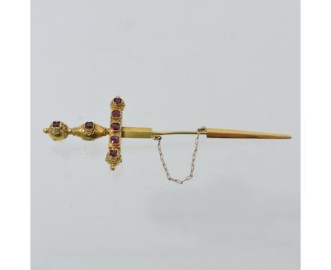 A yellow metal and ruby set pin, in the form of a sword