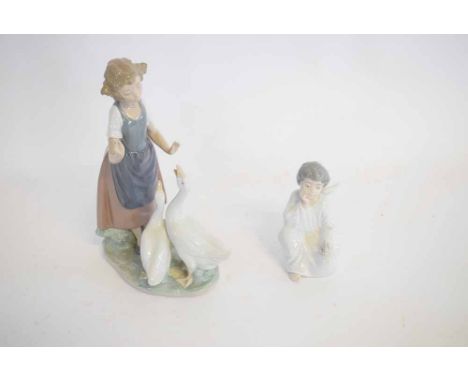 Nao figure of a young girl with two geese, together with a further Nadal seated figure of a young boy with wings with a bird 