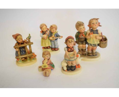 Group of five Goebel Hummel figures to include a group of a young boy and girl with basket on her arm, a further girl by a fe