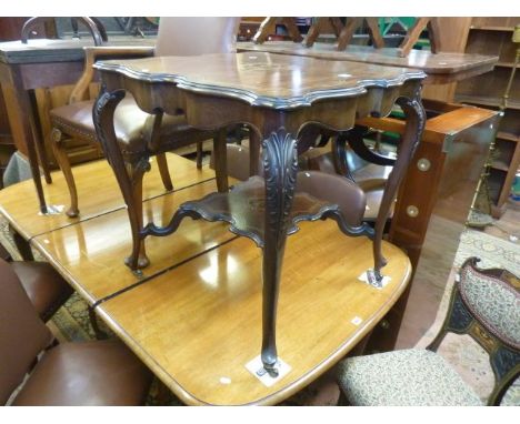 An inlaid Edwardian mahogany centre table with scalloped outline, shaped supports and under gallery with marquetry detail, to