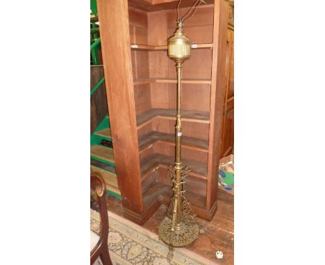 A Victorian Gothic Revival brass oil lamp standard on a pierced base with tripod supports and lions paw feet with adjustable 