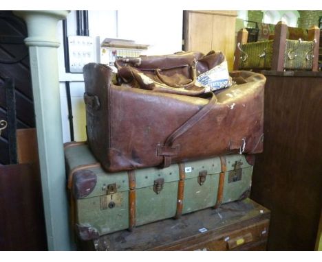 A large vintage leather holdall with leather straps, a further smaller example and a green canvas trunk with timber lathes