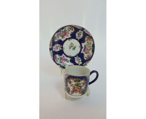 An 18th century Worcester tea cup and saucer with reserved gilded cartouches containing painted floral sprays against a blue 