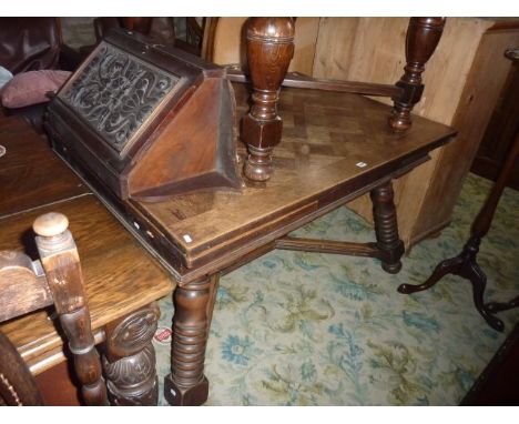 An early 20th century oak draw leaf dining table with parquetry top raised on four turned supports united by an x shaped stre