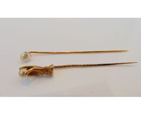 Two stick pins, one with a hand holding a pearl terminal, the other with a pearl terminal (2)