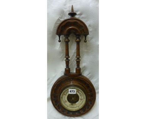 A simple Edwardian aneroid barometer in a carved and moulded case