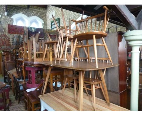 An Ercol rectangular dining table with elm top together with four Ercol stick back dining and a pair of Ercol "Cowhorn" chair