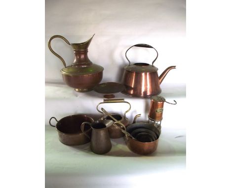 A selection of copper wares to include five graduating lined saucepans with brass handles, a substantial kettle, further kett