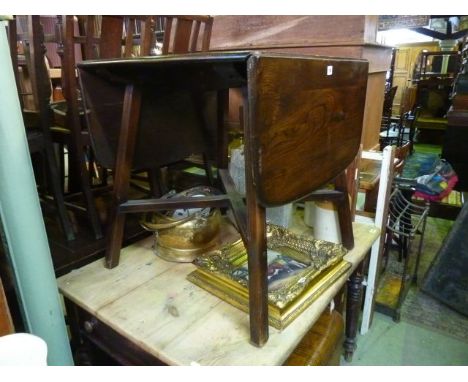 A mid brown Ercol drop leaf dining table in elm on square tapered legs with x shaped stretcher