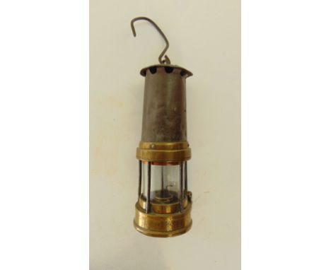 A steel miner's lamp with studded brass mounts