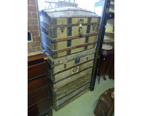 Three vintage travelling trunks in green canvas, timber overlaid with brass fittings and a vintage Remington typewriter