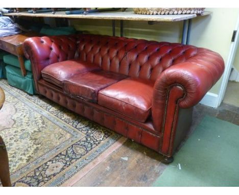 A traditional button back Chesterfield sofa in a red leather colourway