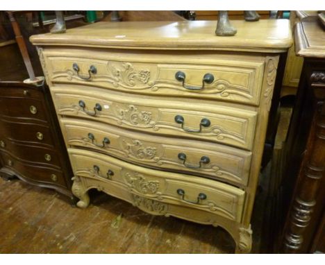 A contemporary oak continental commode with serpentine outline, fitted with four drawers with floral detail, on scrolled supp