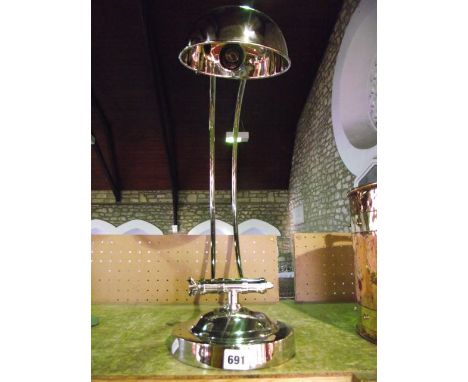 A substantial contemporary nickel plated desk lamp on an adjustable C shaped support with a semi-spherical shade, raised on a