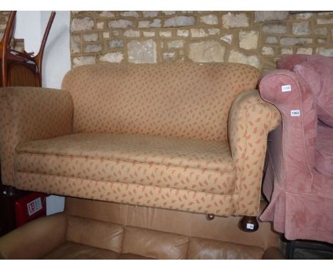 An Edwardian two seat cottage sofa with scrolled arms and rolled back with recently reupholstered finish