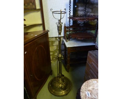 A Victorian brass telescopic oil lamp standard, the circular domed base with heavy embossed floral detail