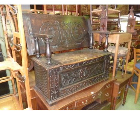 A Victorian oak monks bench/settle with carved detail, the box base set beneath a rising top/back, 100 cm 