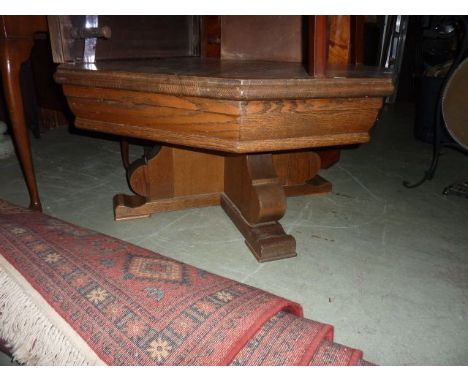 A substantial low occasional table in oak, the octagonal top raised on x shaped supports, 100 cm diameter