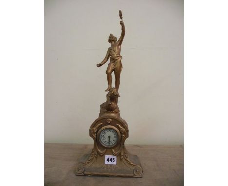 An Edwardian spelter mantel clock enclosing a small 8-day timepiece surmounted by a female athlete astride a lion