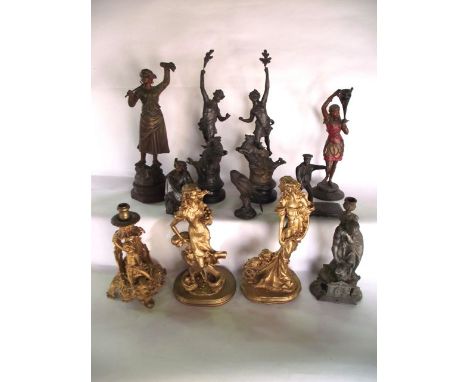 A group of spelter and cast metal figures to include a pair of figures, one male, the other female, striding upon the backs o