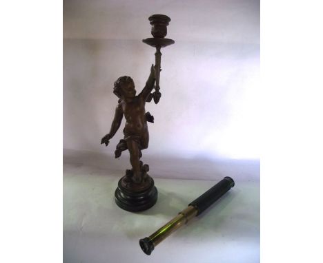 A small pocket telescope and a spelter candlestick with figure support