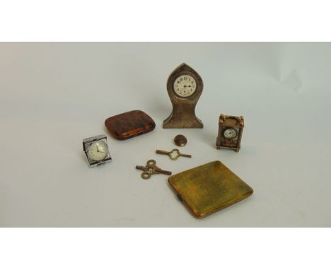 A small travel clock in an engine turned case, an Edwardian silver mounted desk clock, etc