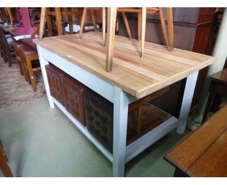 A contemporary kitchen work table of rectangular form with scrubbed pine wood top raised on a painted framework with under ga