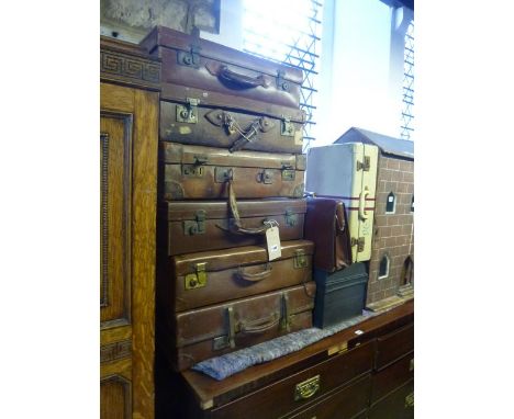 Six vintage suitcases, mainly leather examples, a small tin trunk, a briefcase and a small aluminium case with original paint