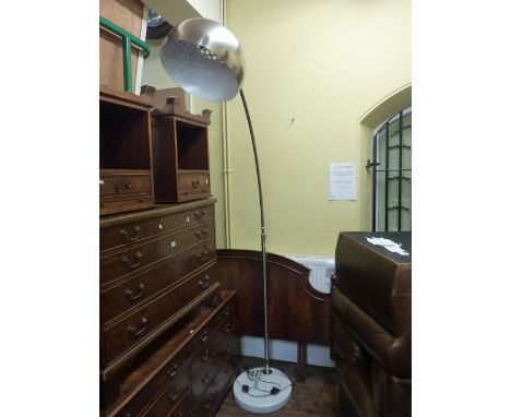 A contemporary lamp standard with heavy marble base and large arched brushed chrome convex arm and polished chromium shade