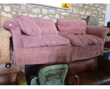 A substantial three seat sofa with pale pink floral embossed loose cover