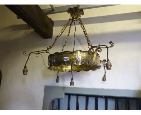 An Edwardian brass ceiling light to support four bulbs, the brass framework with simulated crocodile skin detail