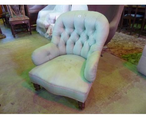 A Victorian drawing room chair with upholstered button framework on turned supports