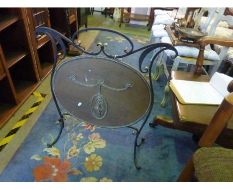 An Edwardian ironwork firescreen with oval brass plate centre