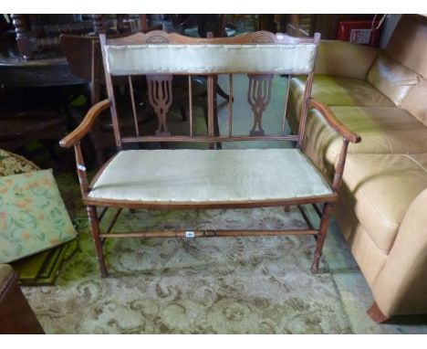 An Edwardian parlour room sofa for two with pierced splats and simple inlaid detail